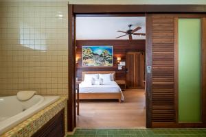 a bedroom with a bed and a bath tub in a room at GajaPuri Resort Koh Chang in Ko Chang