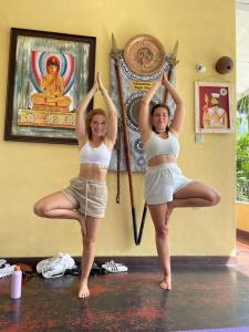 Deux femmes font du yoga dans une pièce dans l'établissement Traditional Kandyan House, à Kandy