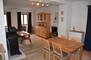 a kitchen and dining room with a table and chairs at Akác Tanya in Alsómóricgát