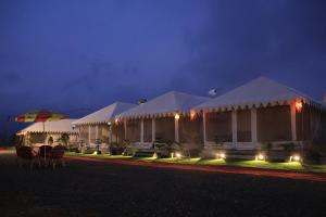 アラハバードにあるShivadya Camps MAHAKUMBH Melaの白いテント(椅子、傘付)
