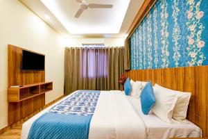 1 dormitorio con 1 cama y TV en Balwood Suites Near Delhi Airport, en Nueva Delhi