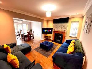 a living room with a couch and a tv at Detached 4 Bed - Pool Table-Patio-BBQ-Table Tennis in Quinton