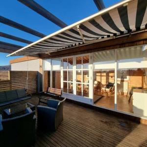 una terrazza con tenda da sole e mobili su una casa di Adventure Eagle Cottege a Geysir