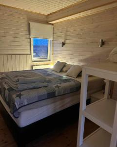 ein Schlafzimmer mit einem Bett in einer Holzwand in der Unterkunft Adventure Eagle Cottege in Geysir