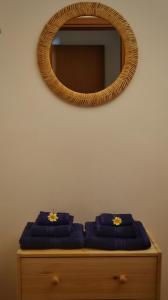 a mirror and two purple towels on a dresser at Villa Ginevra in Balestrate +15 photos