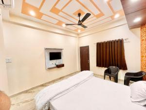 um quarto com uma cama e uma televisão no tecto em Hotel Sunayana Guest House ! Varanasi fully-Air-Conditioned hotel at prime location, near Kashi Vishwanath Temple, and Ganga ghat em Varanasi