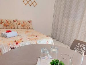 ein Wohnzimmer mit einem Tisch und einem Bett in der Unterkunft JACY AP GOSTOSO in São Miguel do Gostoso