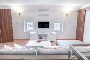 a living room with two couches and a tv at Eternity Apartmanház in Keszthely +50 photos