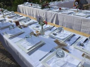 a table with white plates and utensils on it at Les Amis du Moulin 