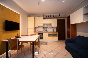 een keuken en een woonkamer met een tafel en een bank bij Appartamento Stefano in Polpenazze del Garda
