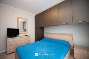een slaapkamer met een bed en een televisie en kasten bij Appartamento Stefano in Polpenazze del Garda