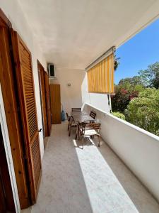 a balcony of a house with a table and a window at LE DUNE Casa vacanze Salento Puglia in Torre dell'Orso