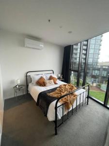 1 dormitorio con cama y ventana grande en Spacious 2 bedroom apartment-free parking-pool-gym-wi-fi, en Belconnen