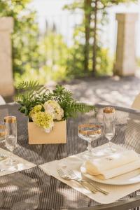 uma mesa com copos de vinho e flores em Villa Antica Colonia - Lake Orta - Suite Apartments Adults Only - SPA & Wellness em Pettenasco