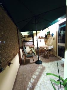 a patio with an umbrella and a table and chairs at Tramonto in Laguna in Càbras