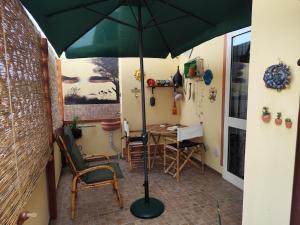 a room with a table with a green umbrella at Tramonto in Laguna in Càbras