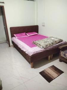 a bed with pink sheets and pillows in a room at Aditi home stay in Ujjain