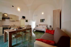 een woonkamer met een bank, een tafel en een bed bij Mini casa in Salento in Cutrofiano