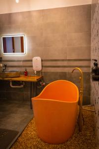 baño con bañera de naranja y lavamanos en Green Mountain Homestay en Ninh Binh