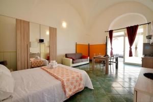 een hotelkamer met een bed en een woonkamer bij Mini casa in Salento in Cutrofiano