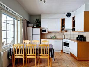 cocina con armarios blancos, mesa y sillas en Apartment Kehtola, Tahkovuori en Kuopio