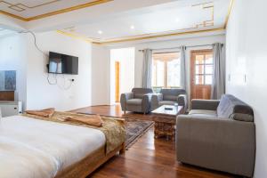 a bedroom with a large bed and a living room at Adu's Eternal Comfort in Leh