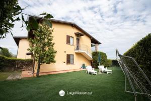 een grote tuin met stoelen en een huis bij Appartamento Stefano in Polpenazze del Garda