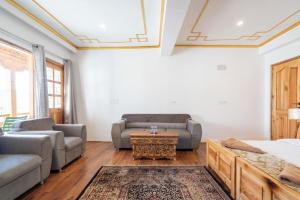a living room with two couches and a table at Adu's Eternal Comfort in Leh