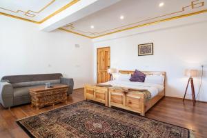 1 dormitorio con 1 cama y 1 sofá en Adu's Eternal Comfort en Leh