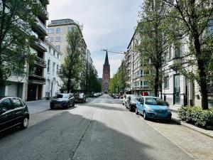 une rue de la ville avec des voitures garées et une tour de l'horloge dans l'établissement Serenity 1201, à Ostende
