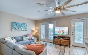 een woonkamer met een bank en een plafondventilator bij Grand Caribbean 316 Community Pool Access Minutes to the ocean front in Perdido Key