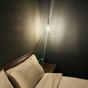 a bedroom with a bed and a lamp on a wall at 遇見 雲山居 in Fuli