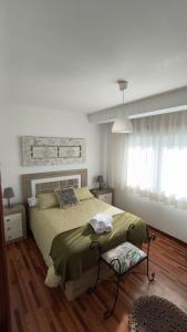 una camera con letto e piumone verde di CasaLola - Corme Porto a La Coruña
