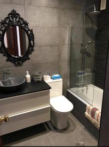 ein Badezimmer mit einem WC, einem Waschbecken und einem Spiegel in der Unterkunft Piso vacacional 7 minutos Cadiz in El Trocadero