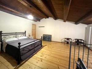 1 dormitorio con 1 cama y suelo de madera en Holiday House Colle del Mondo, en Collecorvino