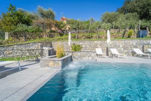a swimming pool with chairs and a stone wall at Villa Chicchi B&B - Sestri Levante in Sestri Levante +81 photos
