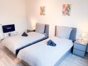 two twin beds in a room with a tv at Monteur- und Ferienwohnung nahe Aachen in Eschweiler
