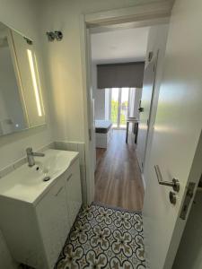 La salle de bains est pourvue d'un lavabo et d'un miroir. dans l'établissement Estrela da Almada Mascarenhas, à Almada