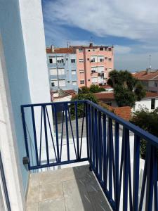 d'un balcon avec une balustrade bleue et certains bâtiments. dans l'établissement Estrela da Almada Mascarenhas, à Almada