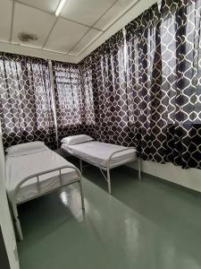 吉隆坡的住宿－Sri Rampai，一间医院房间,设有两张床和壁纸墙