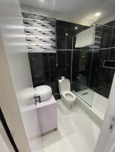 y baño con aseo y ducha acristalada. en KOKO APARTMENT en Lagos