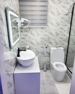 Baño blanco con lavabo y aseo en KOKO APARTMENT en Lagos