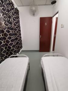 吉隆坡的住宿－Sri Rampai，一间医院房间,设有两张床和一扇门