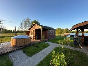 a small house with a hot tub in the yard at Przystań Stare Kotlice in Kotlice