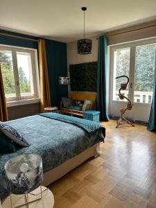 a bedroom with a bed and a chair and windows at Au Ch'Alex in Busset