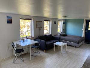1-rom Apartment Sommer - Frøya في Sætra: غرفة معيشة مع أريكة وطاولة