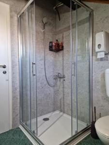 a shower with a glass enclosure in a bathroom at Pansion Oscar Summer Garden in Mostar