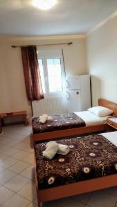 a room with two beds and a refrigerator at Dardiza Stay in Ermioni
