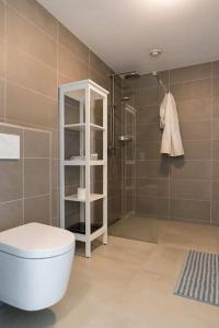 een badkamer met een toilet en een douche bij Nimma Stays Nijmegen in Nijmegen