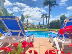 two chairs sitting next to a swimming pool at Hotel Combarro in Combarro